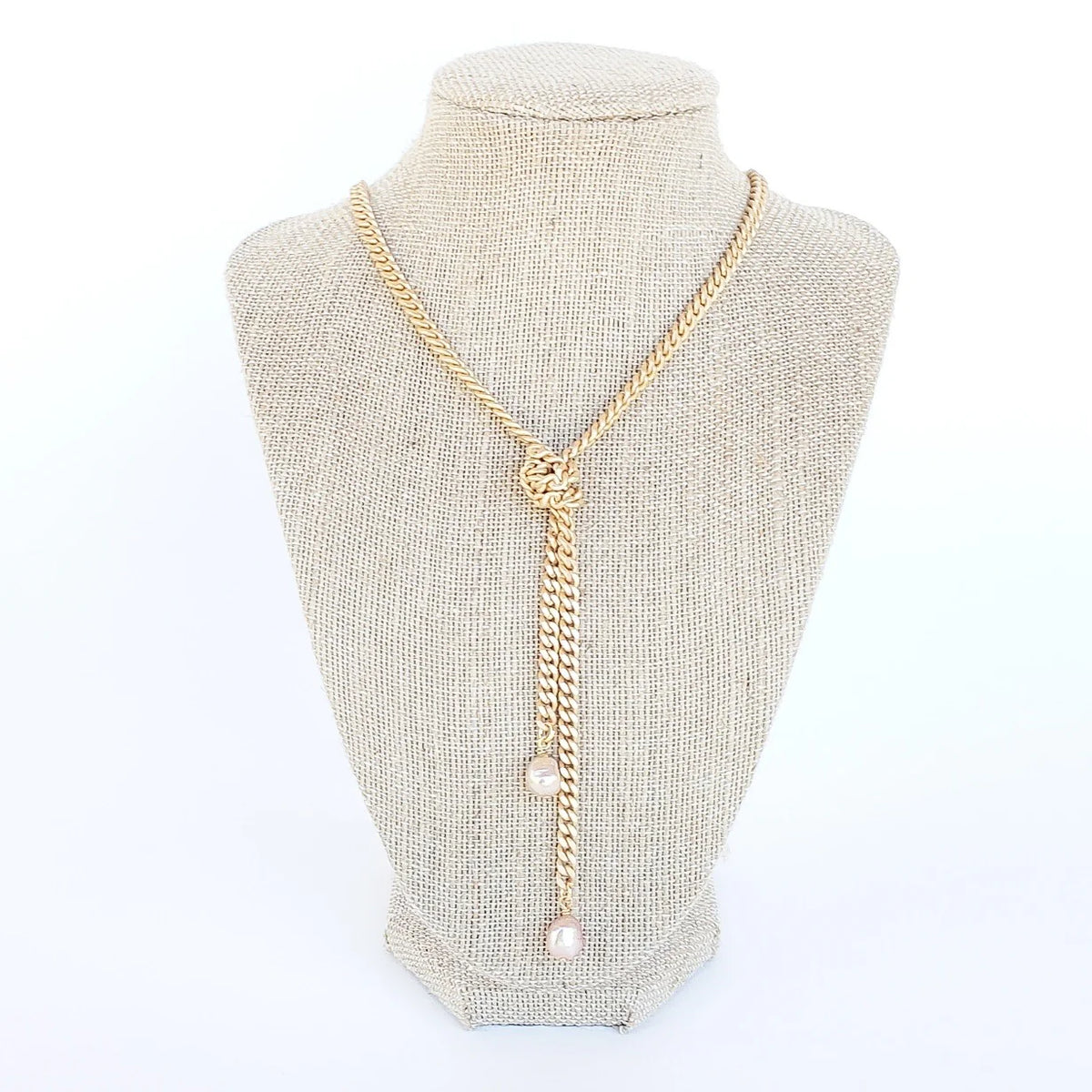 knotted pearl gold chain necklace on white linen jewelry displace