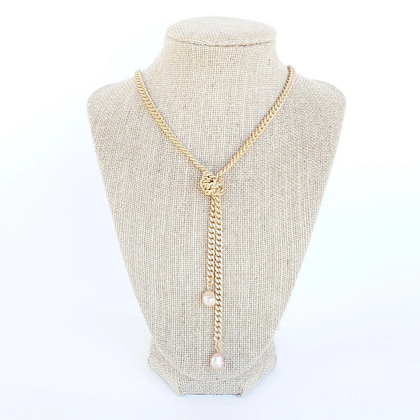 knotted pearl gold chain necklace on white linen jewelry displace